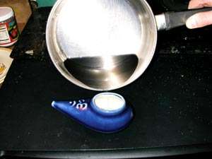 pouring half of the warm salt water into the neti pot